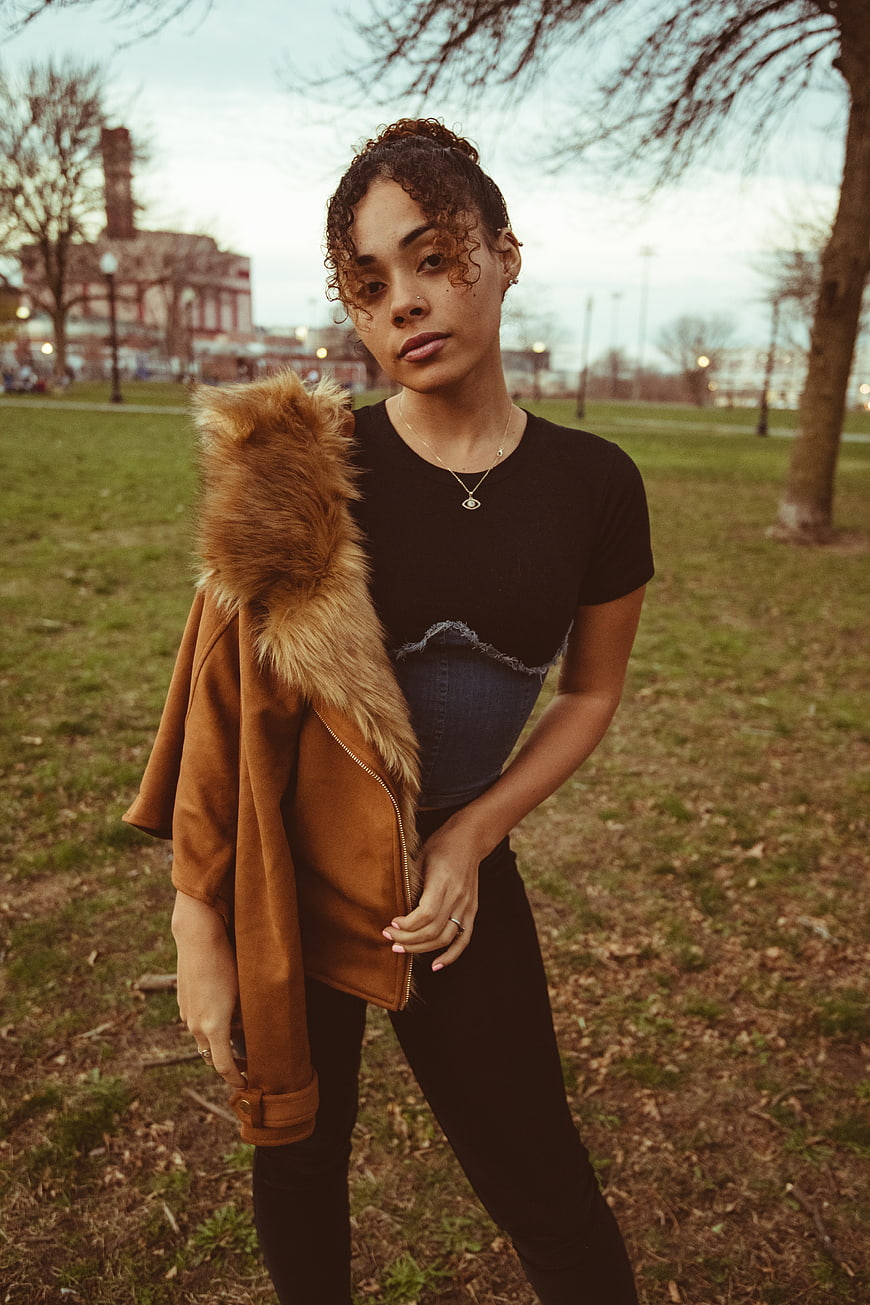 Stylish woman in park wearing brown fur jacket