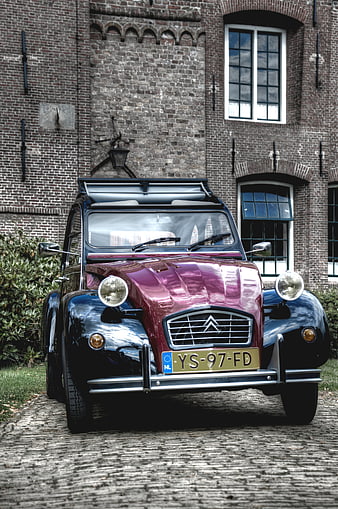Vintage Citroën 2CV parked on cobblestones
