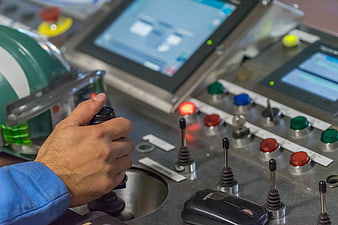 Industrial Operator Hand On Control Panel With Buttons And Screens