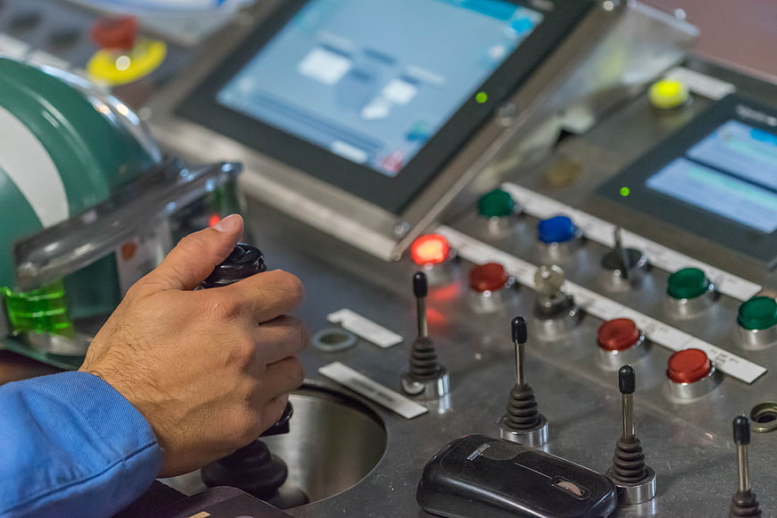 Industrial Operator Hand On Control Panel With Buttons And Screens