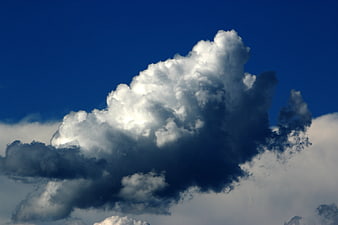 Dramatic cumulus cloud formation against deep blue sky