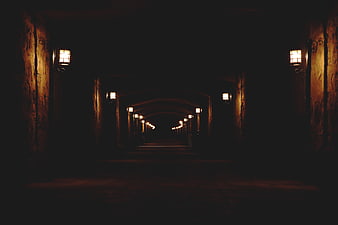 Dark atmospheric tunnel with vintage lanterns at night