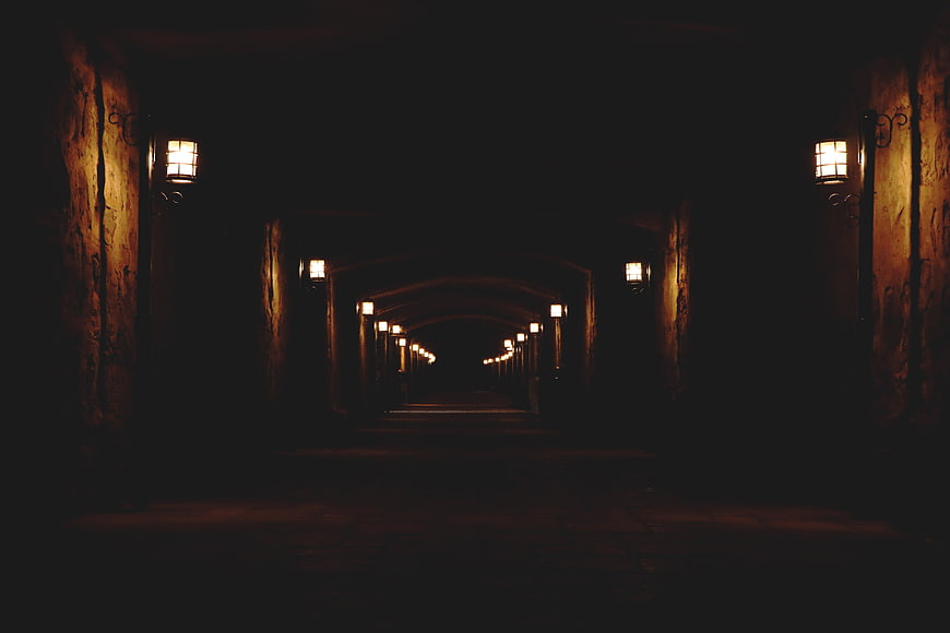 Dark atmospheric tunnel with vintage lanterns at night
