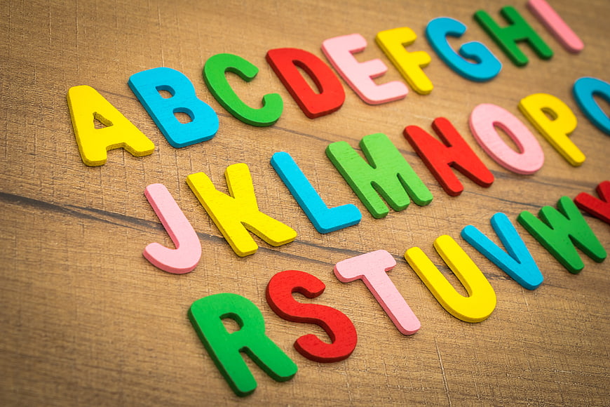Colorful Wooden Alphabet Letters Arranged On Rustic Wood Surface