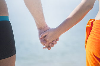 Couple Holding Hands by the Sea in Summer