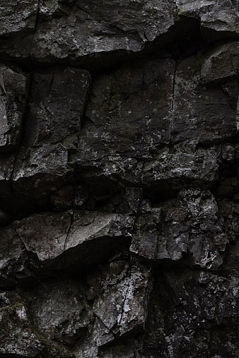 Dark jagged rock texture with lichen details
