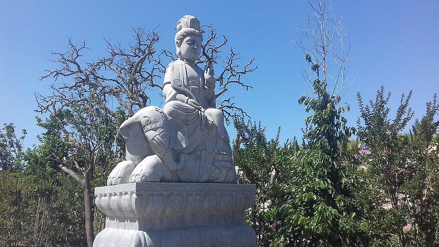 Stone statue of deity riding elephant in garden