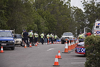 Police officers investigating roadblock with traffic cones and vehicles