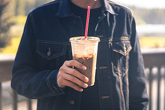 Man in Denim Jacket Holding Iced Coffee