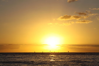 Golden Sunset Over Ocean with Silhouetted Sailboats