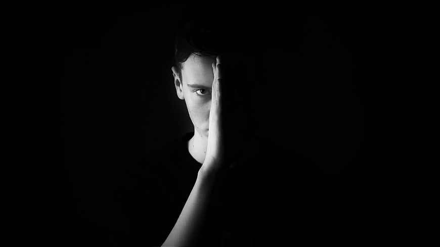 Dramatic black and white portrait of a man hiding face