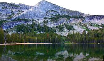Serene Mountain Lake with Granite Peak and Pine Forest Reflection