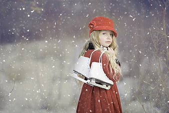 Young Girl in Red Coat Holding Ice Skates in Snow
