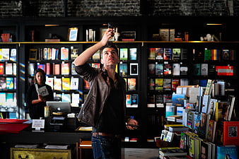 Man taking selfie in bookstore with books