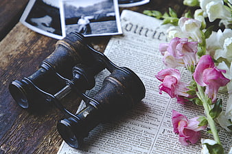 Vintage Binoculars on Old Newspaper with Pink and White Flowers