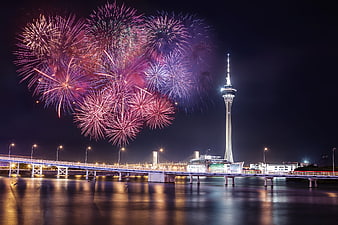 Macau Tower fireworks display over water at night