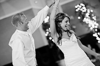 Joyful Bride And Groom Dancing At Wedding Reception In Black And White