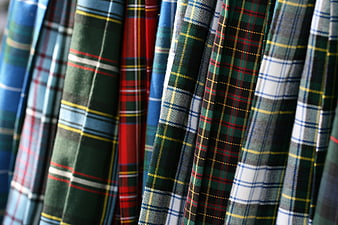 Close-up of colorful plaid fabric rolls hanging in a textile shop