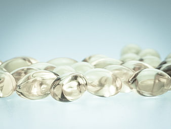 Close-up of clear gel capsules on a light blue background