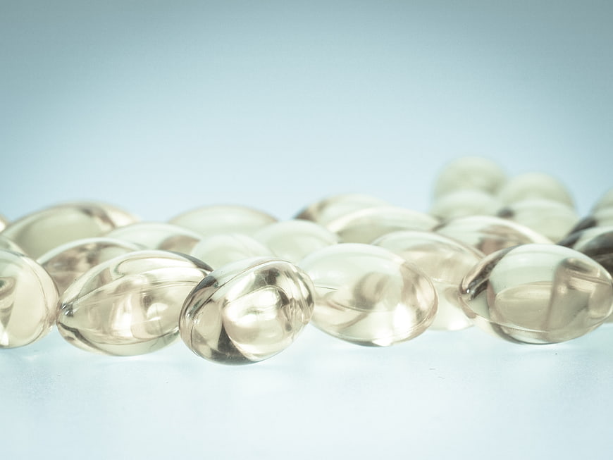 Close-up of clear gel capsules on a light blue background