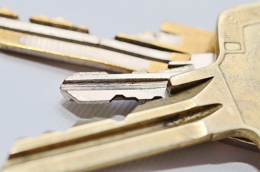 Close-up of brass and silver keys on white background