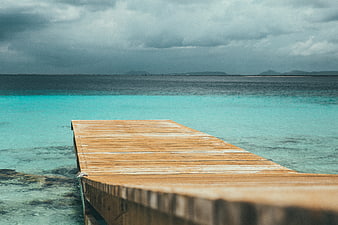 Wooden pier extending into turquoise tropical ocean water