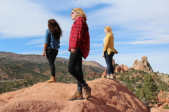 Three women hiking on red rock formation in Garden of the Gods