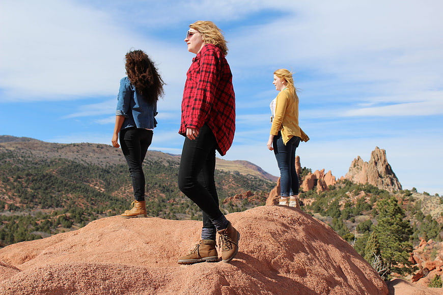 Three women hiking on red rock formation in Garden of the Gods
