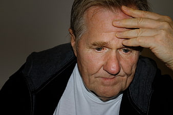 Senior man holding forehead in deep thought or worry