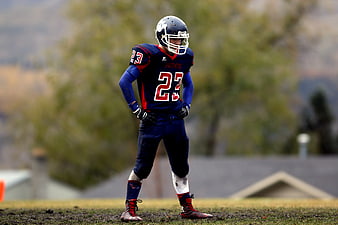 American Football Player in Blue Jersey Standing on Field