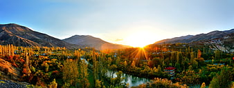 Panoramic autumn landscape with river and mountains at sunset