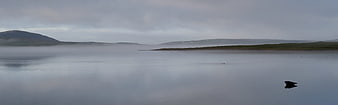 Misty Lake Landscape with Distant Hills and Fog