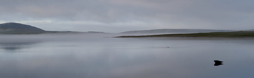 Misty Lake Landscape with Distant Hills and Fog