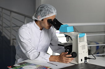 Scientist in Lab Coat Using Microscope in Laboratory