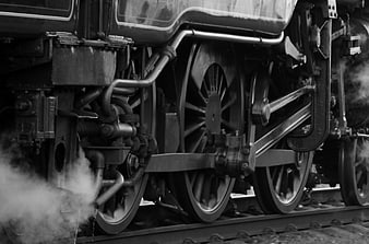 Close-up of vintage steam locomotive wheels and steam