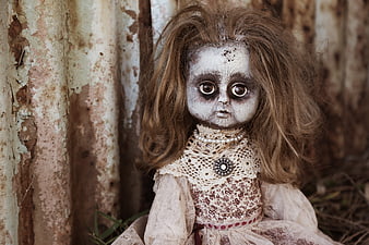Creepy vintage doll with messy hair against rusty background