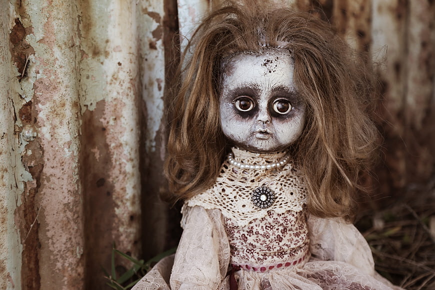 Creepy vintage doll with messy hair against rusty background