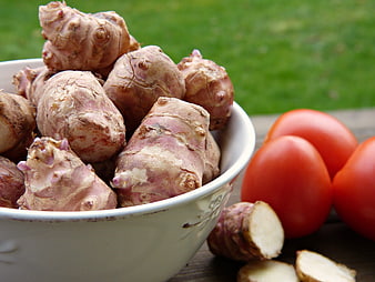Fresh Jerusalem Artichokes in White Bowl with Red Tomatoes