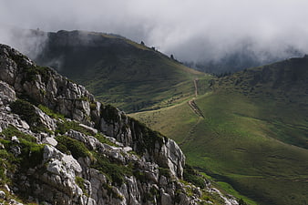 Misty Mountain Landscape with Rocky Foreground and Winding Trail