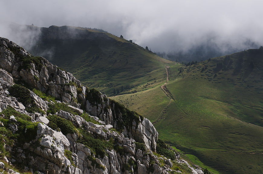 Misty Mountain Landscape with Rocky Foreground and Winding Trail