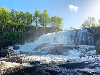 Scenic waterfall cascading over rocks in a forest landscape