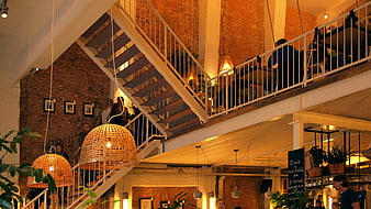 Modern industrial cafe interior with staircase and warm lighting