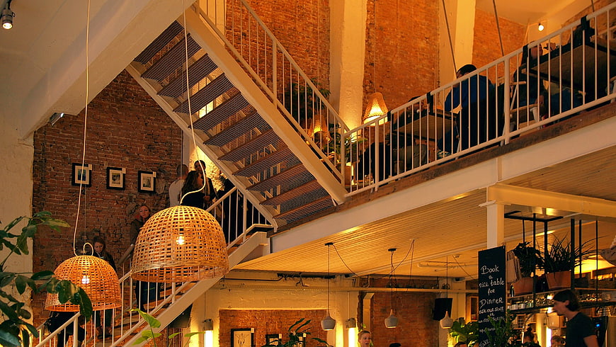 Modern industrial cafe interior with staircase and warm lighting