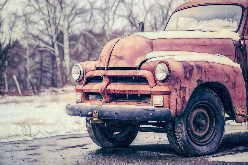 Rusty vintage truck in winter snow