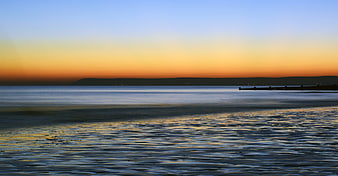 Serene Ocean Sunset With Distant Horizon And Calm Water