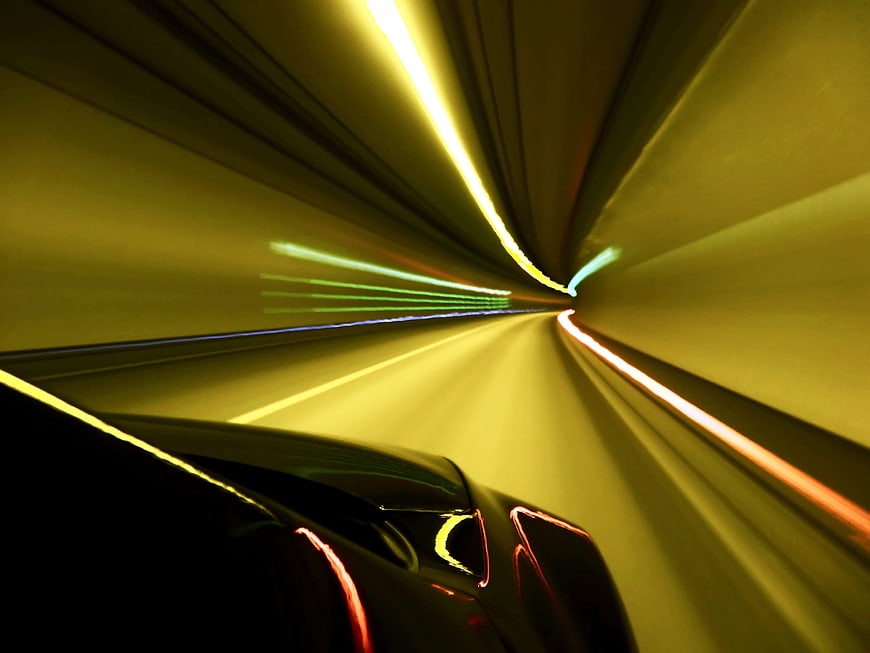 Abstract car driving through tunnel with light trails