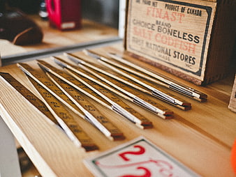Vintage wooden rulers and antique codfish crate on table