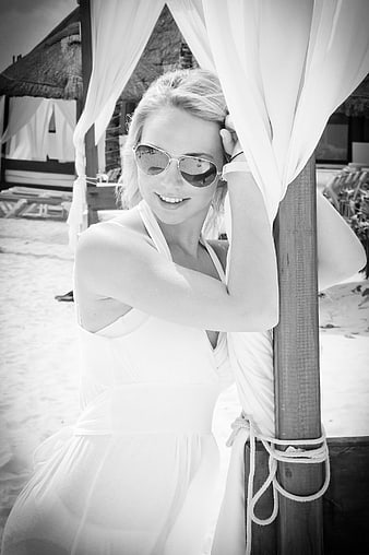 Smiling Blonde Woman in Sunglasses at Beach Cabana