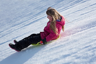 Happy Girl Sledding Down Snowy Hill in Winter