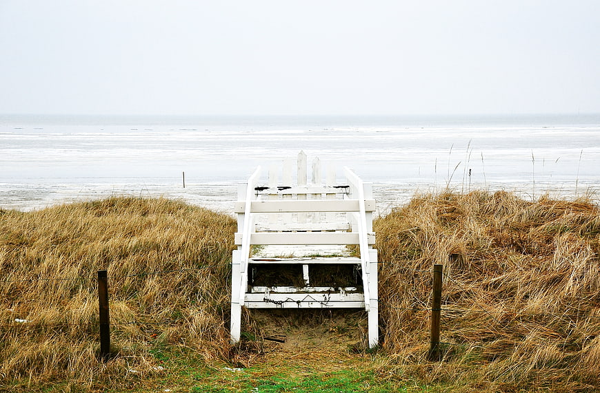 White wooden beach access stairs leading to ocean